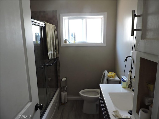 9472 Woodale Ave, Arleta, CA 91331 - bathroom featuring shower / bath combination with glass door, baseboards, toilet, wood finished floors, and vanity