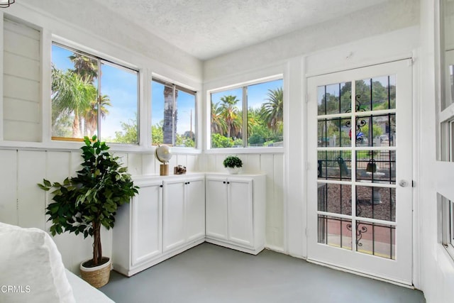 unfurnished sunroom with concrete floors and a textured ceiling