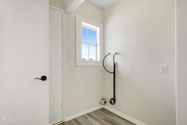laundry area featuring baseboards and light wood finished floors