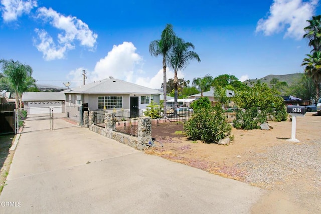 view of front of home featuring stucco siding, a gate, a garage, and a fenced front yard