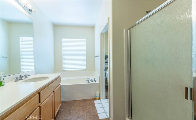 bathroom featuring a shower stall, vanity, and a garden tub