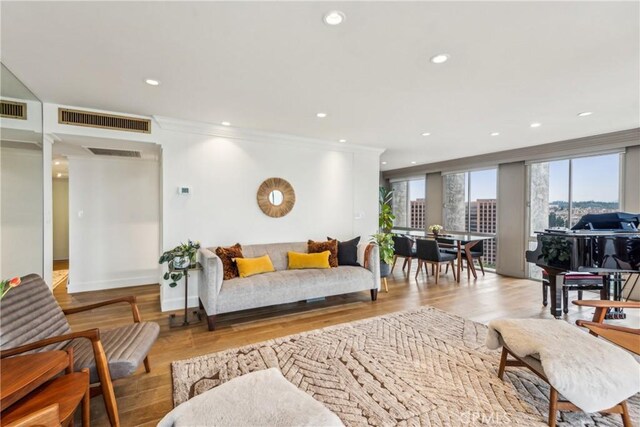 800 W 1st St Unit 1803, Los Angeles, CA 90012 - living room featuring healthy amount of natural light, wood finished floors, baseboards, recessed lighting, and ornamental molding