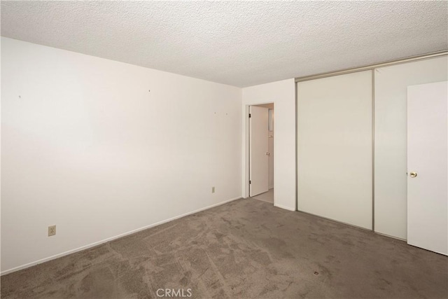 unfurnished bedroom featuring a closet, carpet flooring, and a textured ceiling