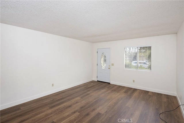 foyer entrance featuring baseboards, dark wood-style flooring, and a textured ceiling
