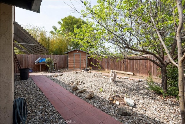view of yard featuring an outbuilding, a fenced backyard, and a shed
