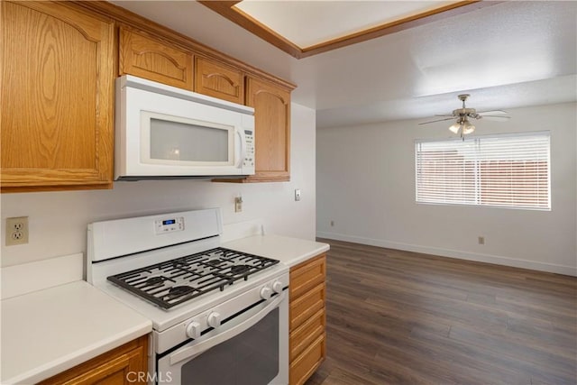 kitchen with light countertops, baseboards, white appliances, ceiling fan, and dark wood-type flooring