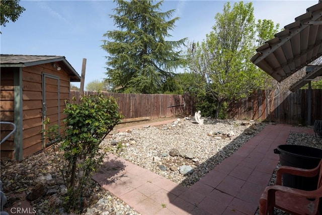 view of yard featuring a patio, an outbuilding, and a fenced backyard
