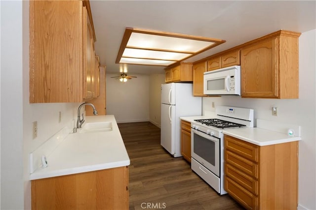 kitchen featuring light countertops, white appliances, a sink, dark wood-style floors, and ceiling fan