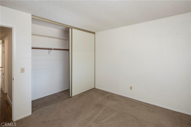 unfurnished bedroom with a closet, a textured ceiling, and carpet