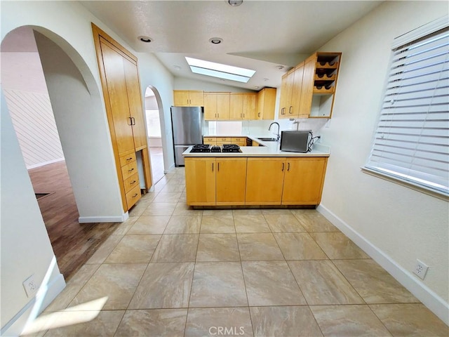 327 Mccarthy Ave, Oceano, CA 93445 - kitchen featuring freestanding refrigerator, a skylight, vaulted ceiling, a peninsula, and a sink