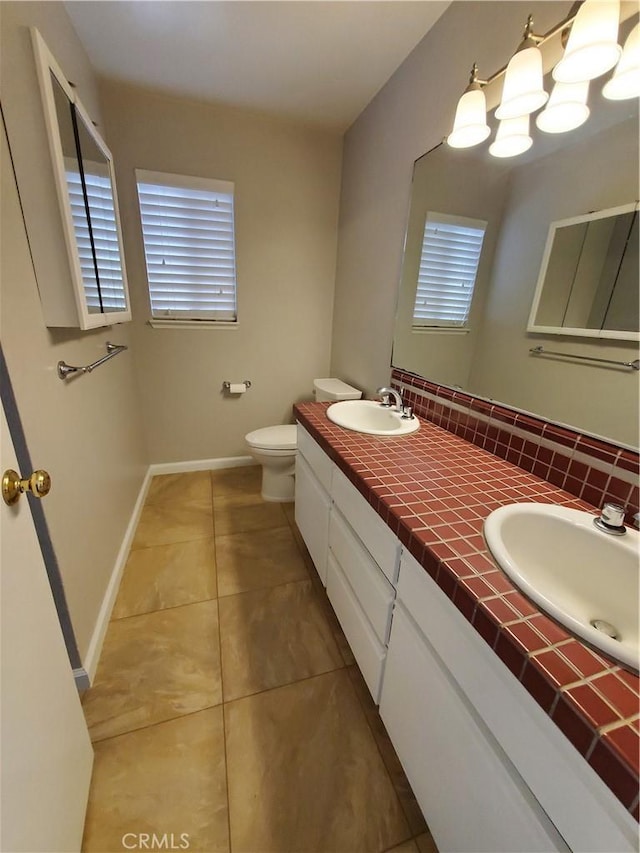 327 Mccarthy Ave, Oceano, CA 93445 - full bath with double vanity, tile patterned flooring, toilet, baseboards, and tasteful backsplash