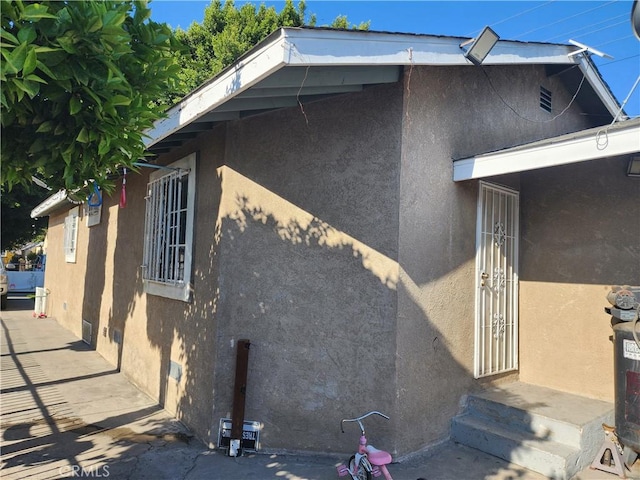 242 E 92nd St, Los Angeles, CA 90003 - view of side of home featuring stucco siding