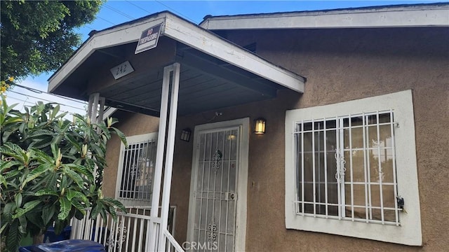 242 E 92nd St, Los Angeles, CA 90003 - doorway to property featuring stucco siding
