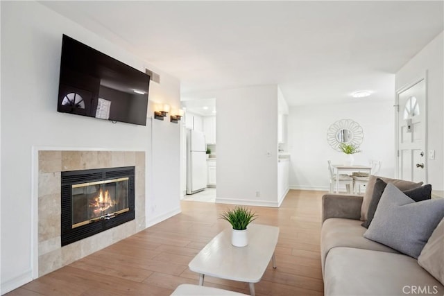 22230 S Vermont Ave Unit 102B, Torrance, CA 90502 - living area with light wood-style flooring and a tiled fireplace