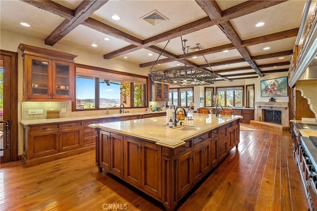 kitchen featuring a sink, visible vents, coffered ceiling, and hardwood / wood-style flooring