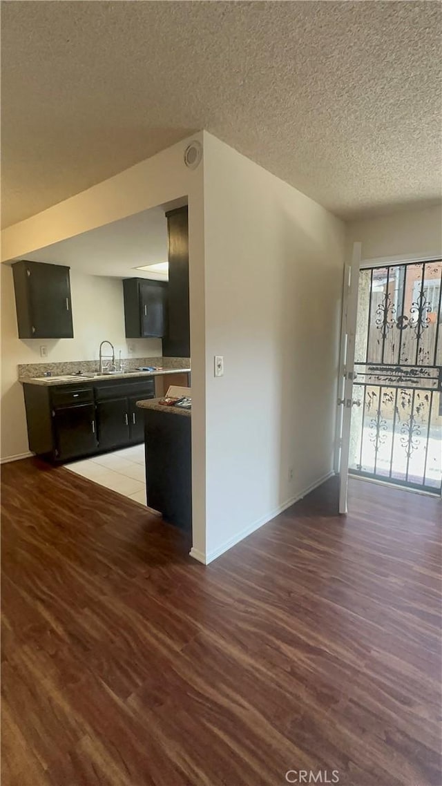 1524 Acacia St Unit 3, Alhambra, CA 91801 - kitchen with dark cabinets, wood finished floors, baseboards, light countertops, and a textured ceiling