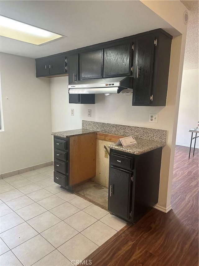 1524 Acacia St Unit 3, Alhambra, CA 91801 - kitchen featuring dark cabinets, under cabinet range hood, light wood-type flooring, and baseboards