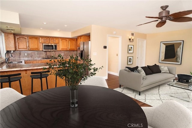 dining space featuring baseboards, recessed lighting, light wood finished floors, and ceiling fan