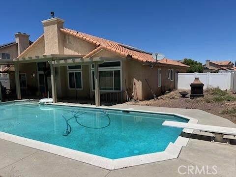 12325 Atoka Ln, Victorville, CA 92392 - view of pool with a patio area, a diving board, and a fenced backyard