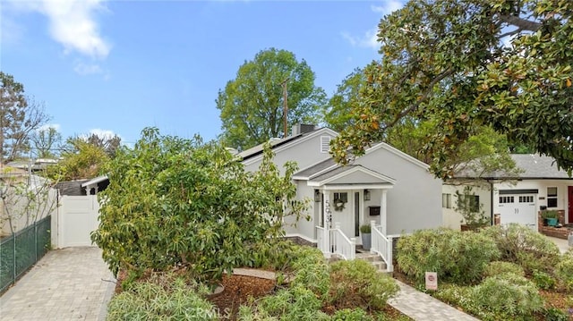 view of front of house with a gate, stucco siding, and fence