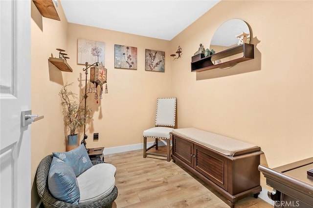 sitting room with baseboards and light wood-style floors