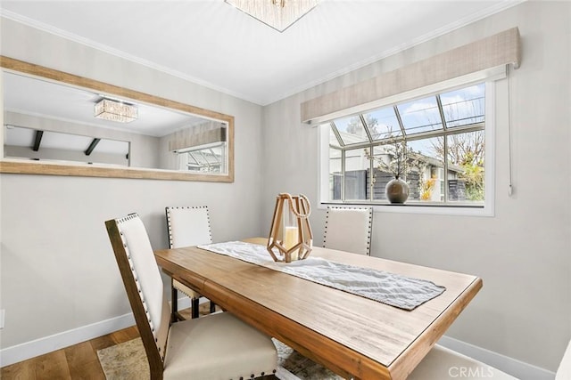 dining room featuring baseboards, a notable chandelier, wood finished floors, and crown molding