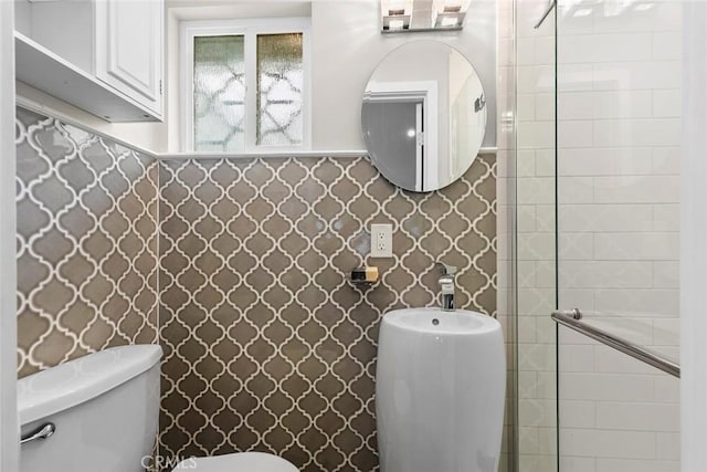 bathroom featuring toilet and tiled shower