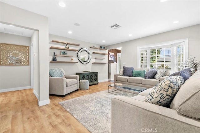 living room with baseboards, visible vents, light wood-style floors, and recessed lighting