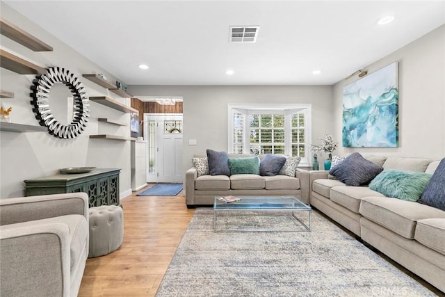 living room with recessed lighting, visible vents, and light wood-style floors