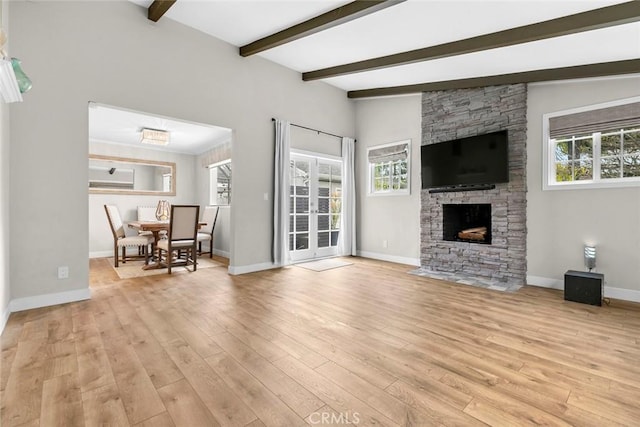 living area with baseboards, a fireplace, and light wood-style floors