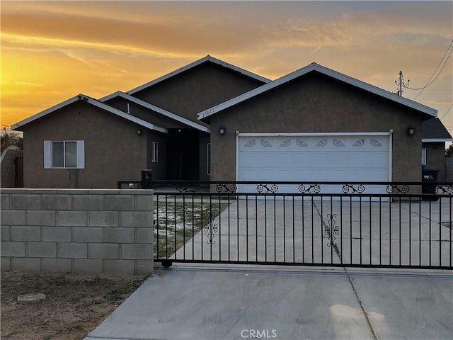 view of front of property with a garage, driveway, and stucco siding