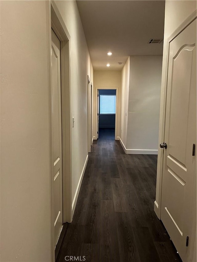 corridor featuring baseboards, visible vents, recessed lighting, and dark wood finished floors