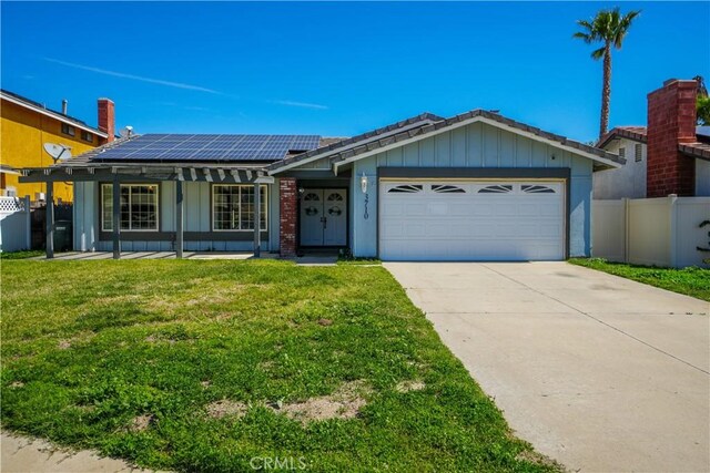 3710 Colonial Cir, Lake Elsinore, CA 92530 - ranch-style home featuring a front lawn, a garage, roof mounted solar panels, concrete driveway, and fence