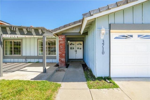 3710 Colonial Cir, Lake Elsinore, CA 92530 - doorway to property featuring a garage, brick siding, and board and batten siding