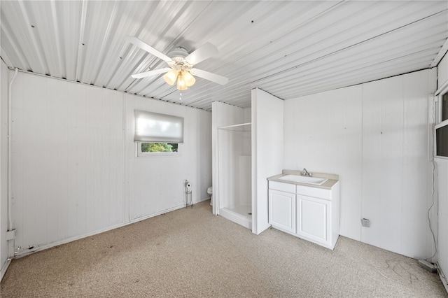 unfurnished bedroom with ceiling fan, light carpet, and a sink