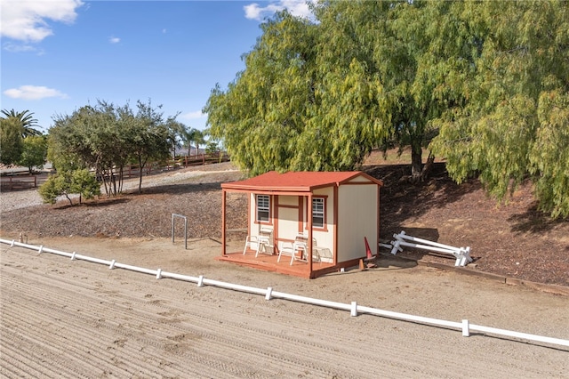 view of outbuilding featuring fence and an outdoor structure