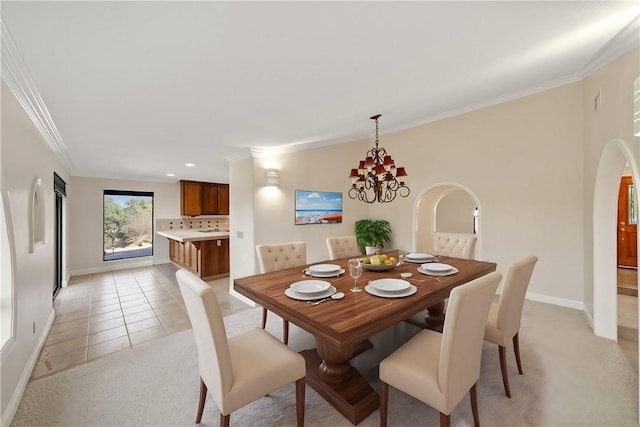 dining space featuring crown molding, baseboards, arched walkways, and a chandelier