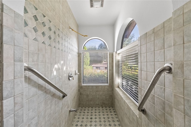 bathroom featuring tile walls and tiled shower