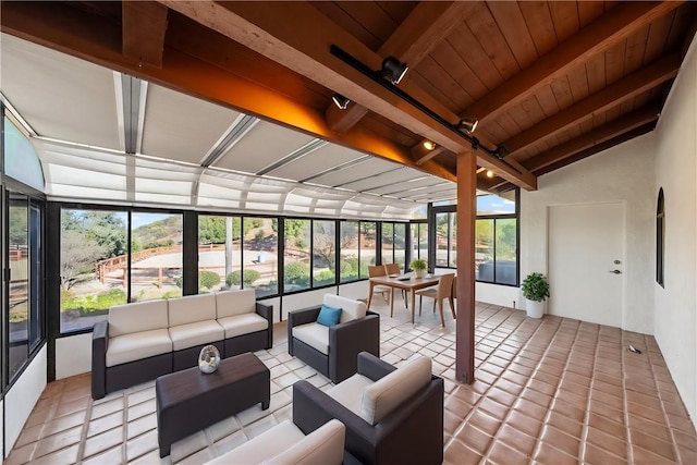 sunroom / solarium featuring lofted ceiling with beams, wooden ceiling, and a wall of windows