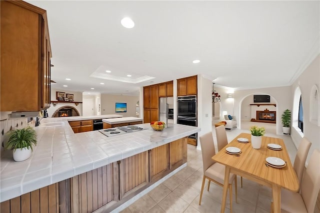 kitchen featuring crown molding, cooktop, dobule oven black, and a peninsula
