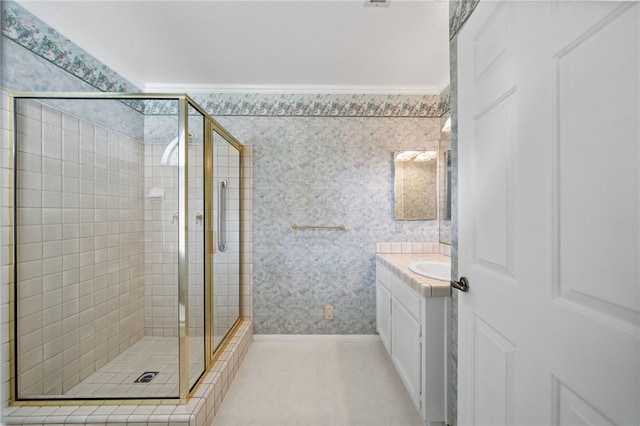 bathroom with crown molding, a stall shower, vanity, baseboards, and wallpapered walls