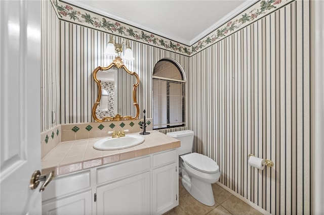 half bath with vanity, tile patterned floors, toilet, and wallpapered walls