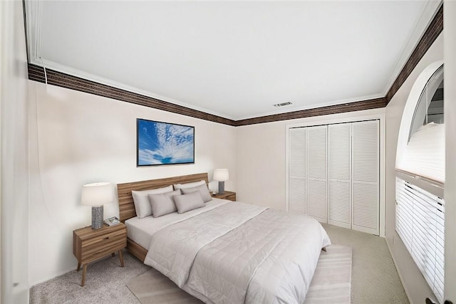 bedroom featuring visible vents, light carpet, ornamental molding, and a closet