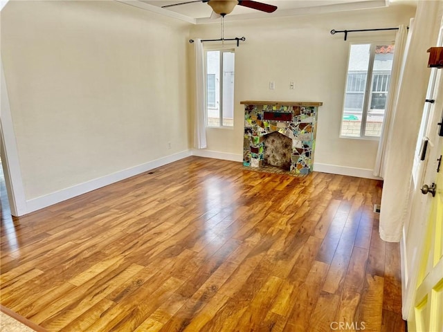 unfurnished living room featuring hardwood / wood-style floors, a ceiling fan, and plenty of natural light