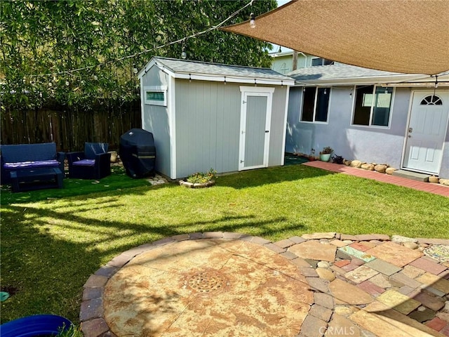 view of yard featuring fence, an outbuilding, and a shed
