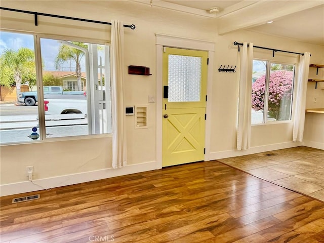 doorway to outside with hardwood / wood-style floors, visible vents, and baseboards