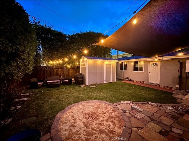 rear view of house with a yard, outdoor lounge area, an outbuilding, and a patio area