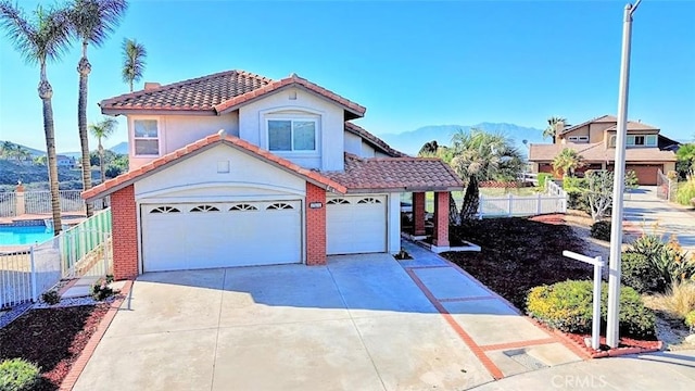 mediterranean / spanish-style house with stucco siding, fence, a tiled roof, driveway, and a garage