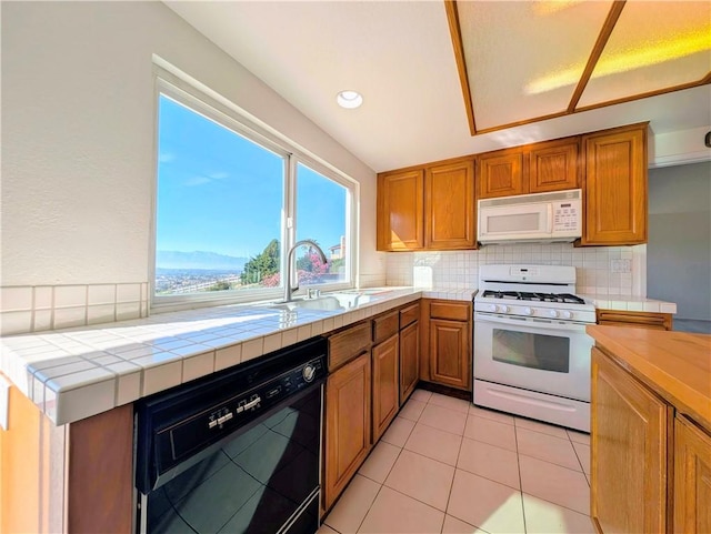kitchen with decorative backsplash, a sink, tile countertops, and white appliances