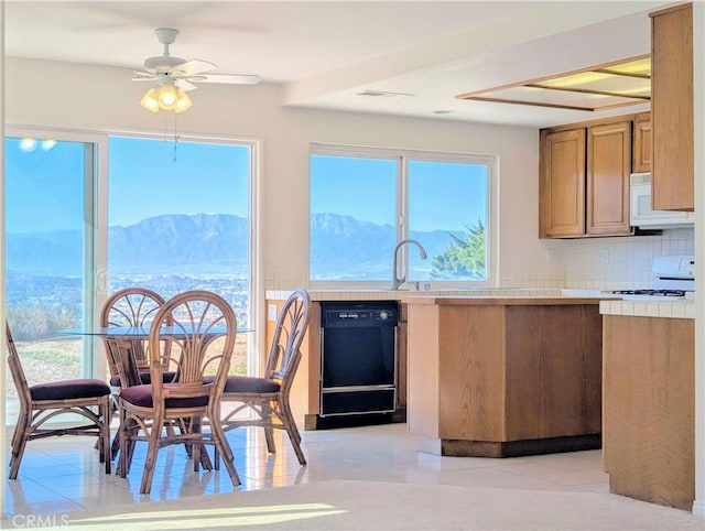 kitchen with black dishwasher, white microwave, and a healthy amount of sunlight